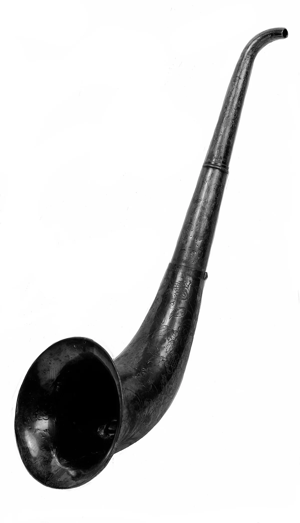 Long curved metal ear trumpet with engraved floral decoration on a white background